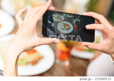 Woman photographing food by smartphone 23380513
