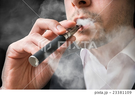 Man is smoking electronic cigarette or vaporizer. 23381109
