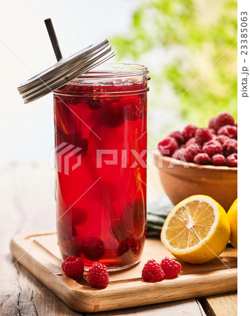 Ice cold drink glass with raspberry and lemon 23385063