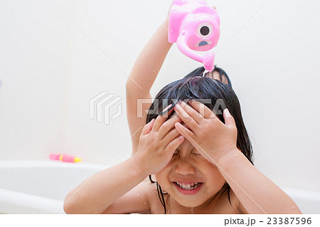お風呂で遊んでいる子供姉妹の写真素材
