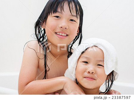 お風呂で遊んでいる子供姉妹の写真素材
