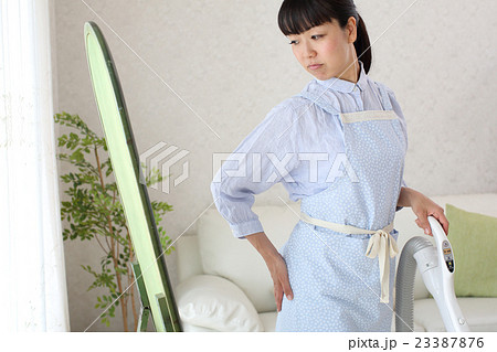 掃除をしながら体型の衰えに悩む主婦 掃除をしながら体型の衰えに悩む主婦 23387876