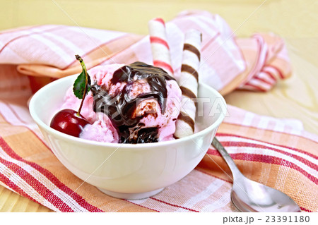 Ice cream cherry with wafer rolls on board 23391180