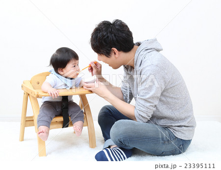 子どもに離乳食をあげるパパ 23395111