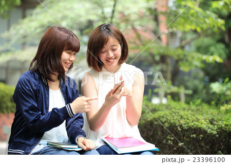スマホを眺める女子大生の写真素材