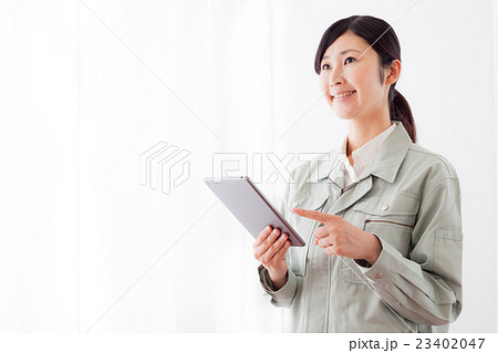 作業着の女性、タブレットパソコン、指差し 作業着の女性、タブレットパソコン、指差し 23402047