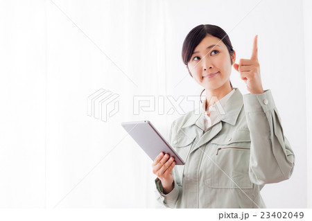 作業着の女性、タブレットパソコン、指差し 作業着の女性、タブレットパソコン、指差し 23402049