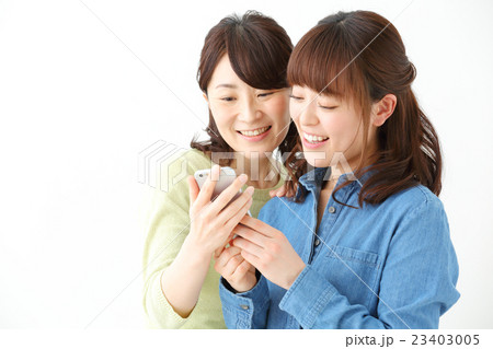 スマートフォンを見る女性たち スマートフォンを見る女性たち 23403005