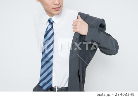 スーツに袖を通す若いビジネスマンの写真素材