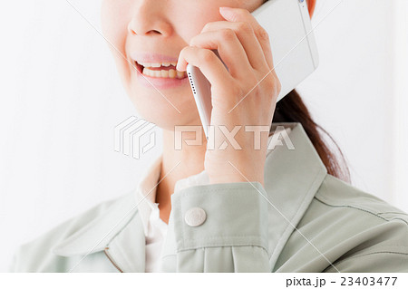 作業着を着る女性、携帯電話、ポジティブ 作業着を着る女性、携帯電話、ポジティブ 23403477