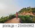 Woman standing shooting mountain road by the sea 23404962