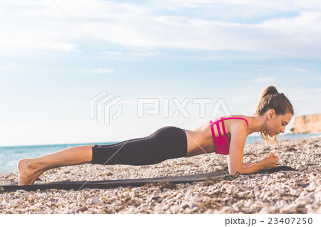 Dancer woman doing plank on the beach 23407250