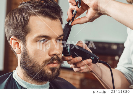 The hands of young barber making haircut The hands of young barber making haircut 23411380