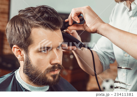 The hands of young barber making haircut The hands of young barber making haircut 23411381