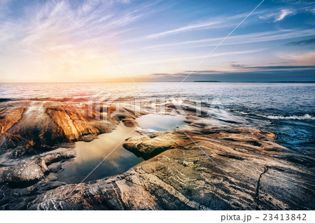 Stone coast of Ladoga lake at sunset 23413842