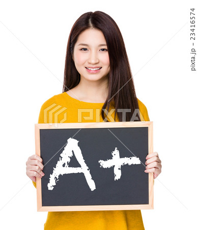 Woman hold blackboard showing sign of A plus 23416574