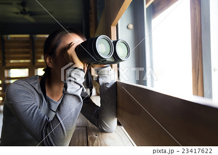 Young Woman use of the binoculars at indoor Young Woman use of the binoculars at indoor 23417622