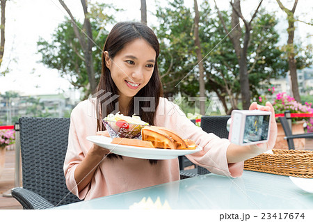 Woman taking photo with her waffle in restaurant 23417674