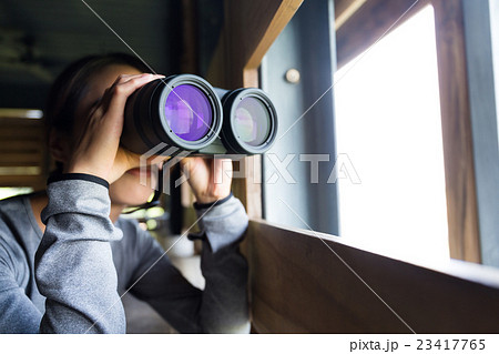 Young woman use of the telescope at wooden house 23417765