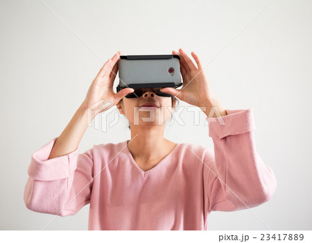 Woman watching though virtual reality device Woman watching though virtual reality device 23417889