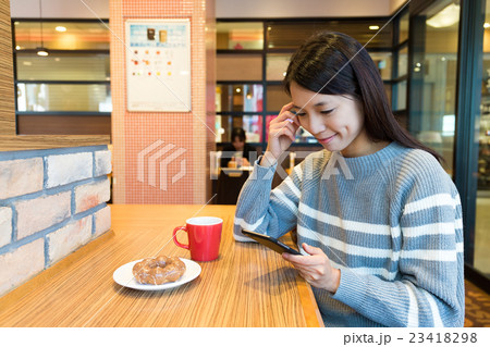 Woman use of mobile phone at coffee shop Woman use of mobile phone at coffee shop 23418298
