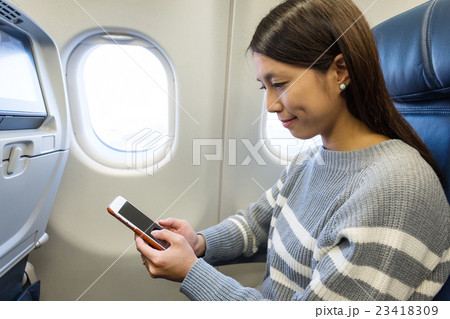 Woman use of cellphone inside aircraft 23418309