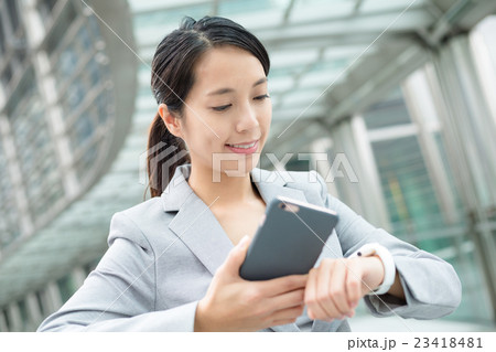 Business woman connecting smart watch and mobile phone Business woman connecting smart watch and mobile phone 23418481
