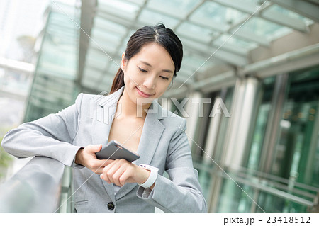Business woman using smart watch and cellphone Business woman using smart watch and cellphone 23418512