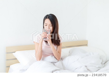 Woman having a glass of water at bed Woman having a glass of water at bed 23418570