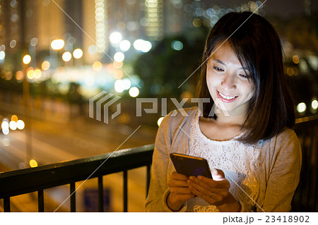 Woman sending sms on mobile phone at outdoor 23418902