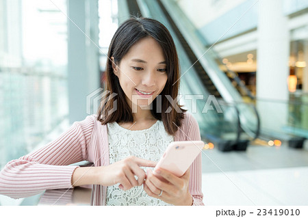 Woman browsing on cellphone Woman browsing on cellphone 23419010