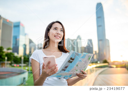 Woman using cellphone and city map in Hong Kong 23419077