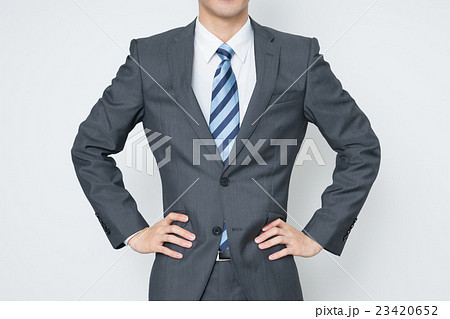 腰に手をあてる若いビジネスマンの写真素材