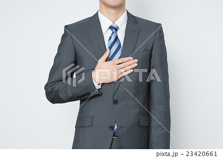 胸に手を当てる若いビジネスマンの写真素材