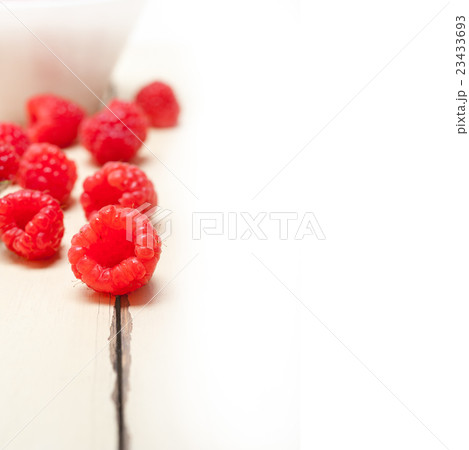 bunch of fresh raspberry on a bowl and white table 23433693