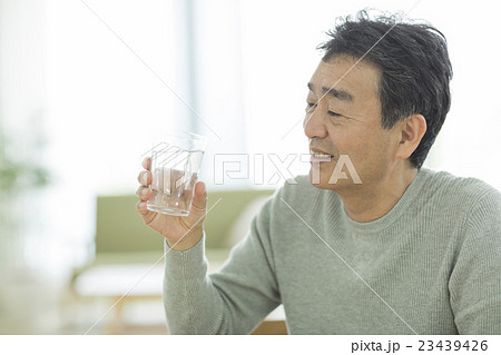 コップに入った水を持つ男性の写真素材