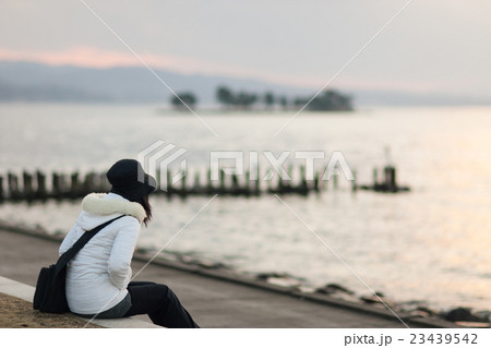 夕暮れの宍道湖畔に佇む女性 23439542