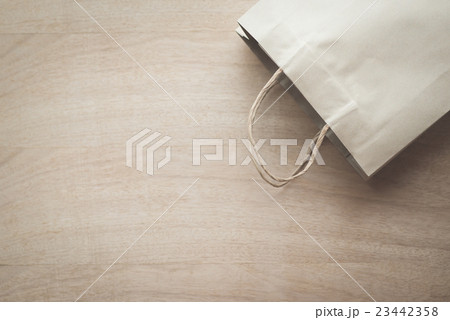 Paper bag on a wooden background 23442358