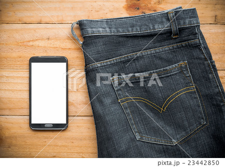 the jeans and mobile phone on wooden board 23442850