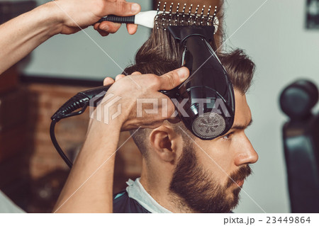 The hands of young barber making haircut to The hands of young barber making haircut to 23449864