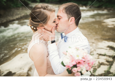 Bride smiles with closed eyes while groom touches Bride smiles with closed eyes while groom touches 23450943