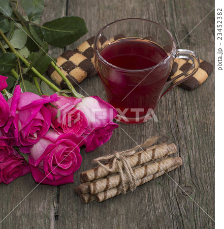 cup of tea, bouquet of roses and various cookies 23452382