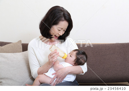 赤ちゃんにミルクをあげる女性の写真素材