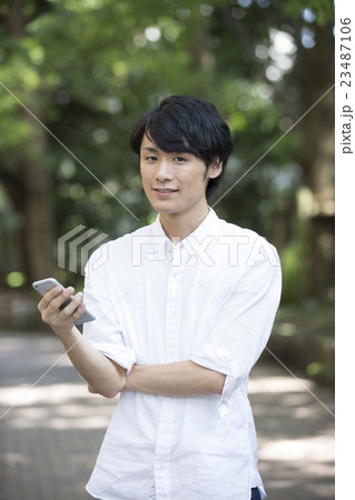スマートフォンを見る若い男性 スマートフォンを見る若い男性 23487106