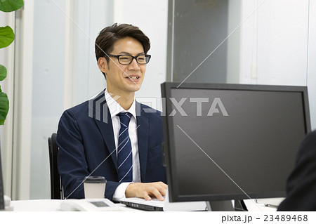 デスクワークをする若いビジネスマン 23489468