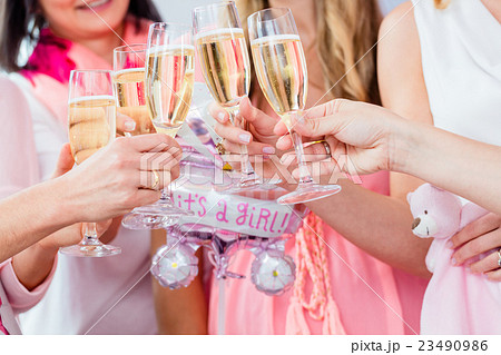 Friends clinking glasses on baby shower party Friends clinking glasses on baby shower party 23490986