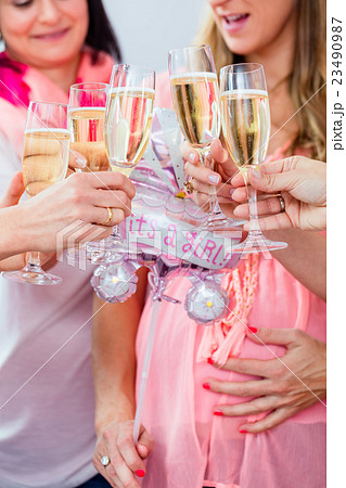 Friends clinking glasses on baby shower party Friends clinking glasses on baby shower party 23490987