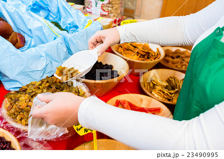 Woman filling meze starters in container 23490995