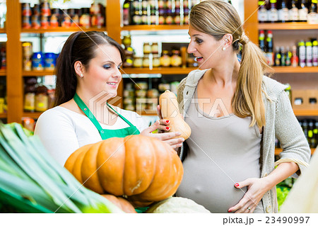 Woman buying pumpkin and vegetables in market 23490997