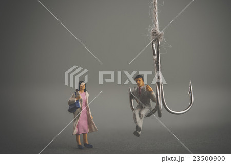 釣り針と男性に近寄る女性 23500900